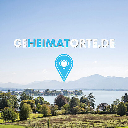 Bild eines Sees inklusive Bergpanorama in dem das Logo geheimatorte.de steht