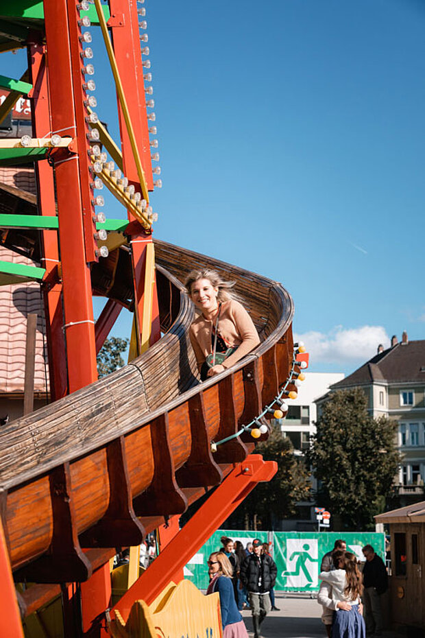 Person auf der traditionellen Toboggan-Rutsche einer Oktoberfest-Attraktion in München.
